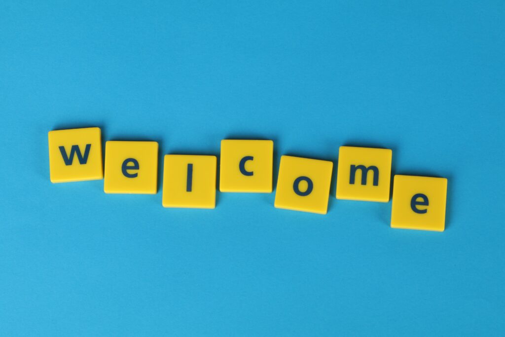 Bienvenidos al blog de Tula Yoga Yellow tiles spelling 'welcome' on a blue background, perfect for greetings.